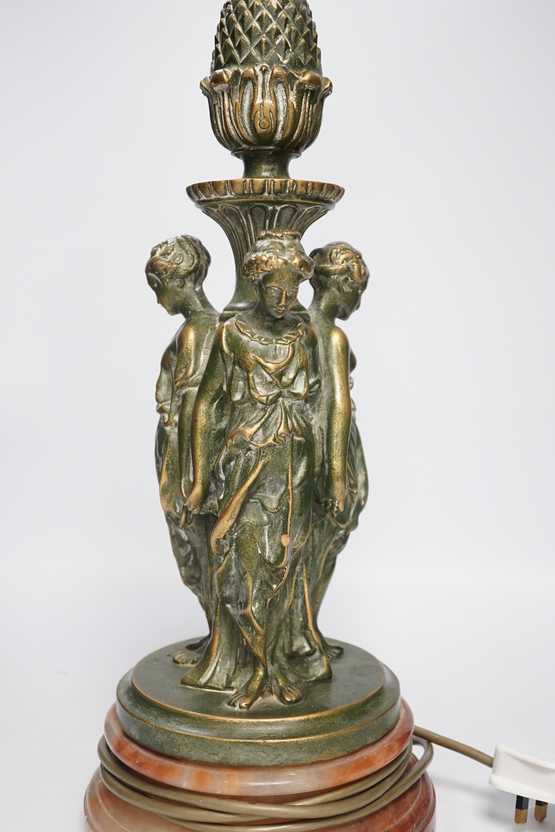 A Three Graces painted resin table lamp, partially gilded, raised on circular rouge marble base, 51cm high overall